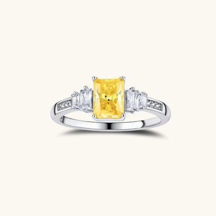 Yellow moissanite jewelry set with emerald-cut stones in sterling silver halo settings on white background.