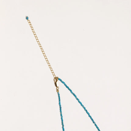 Dainty teal apatite beaded necklace with a single freshwater pearl centerpiece flanked by two small gold beads, adjustable gold clasp.