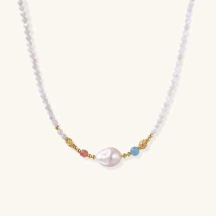 Beaded necklace with small white moonstone beads, central baroque freshwater pearl, coral and blue stone accents, gold floral spacers.