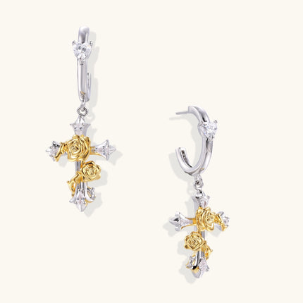 Two-tone silver and gold-plated cross drop earrings with rose motifs and zirconia stones on a huggie hoop base.