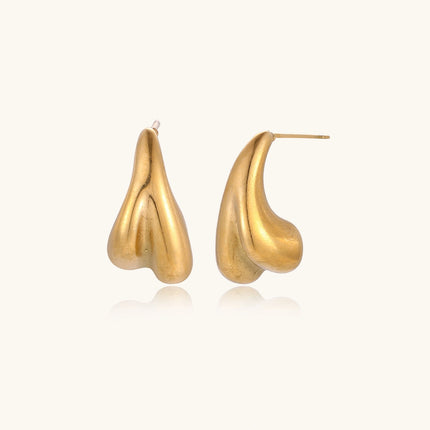 Organic sculptural gold stud earrings with fluid matte finish on cream background