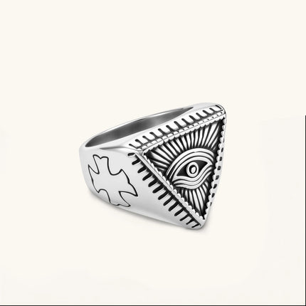 Silver stainless steel signet ring with engraved all-seeing eye in triangle, radiating lines, and cross motifs on the band.