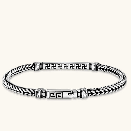Silver stainless steel men's bracelet with braided foxtail chain, Greek key engraved bar, and decorative cube connectors.