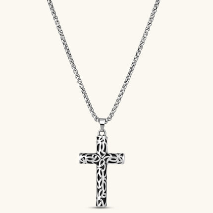 Silver stainless steel Celtic cross pendant with filigree vine pattern on a box chain, against a cream background.