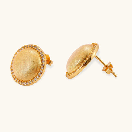 Pair of round dome stud earrings in brushed 18K gold-plated silver with a sparkling CZ halo border, push-back closure.