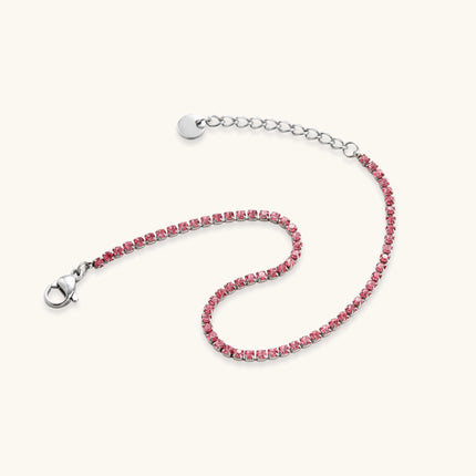 Pink zircon tennis bracelet with silver-tone stainless steel setting and lobster clasp extender chain, flat lay.